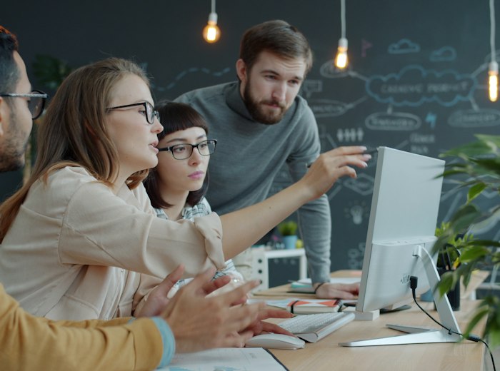 Team members discussing ideas at a desk