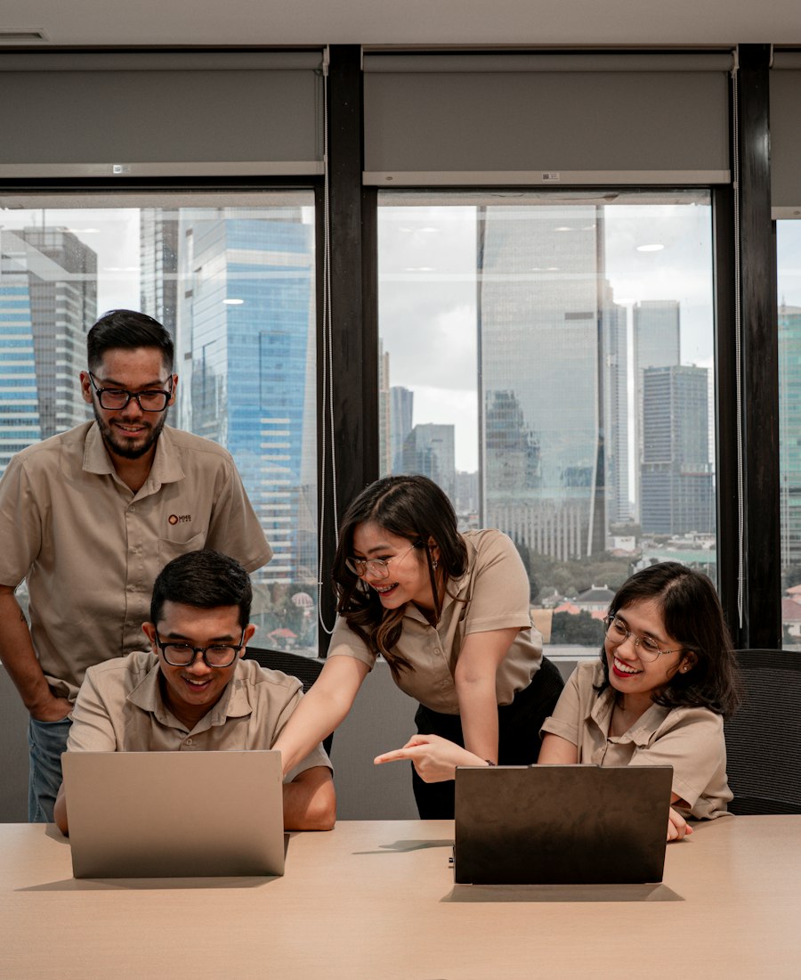 Colleagues working together around laptops in a city office